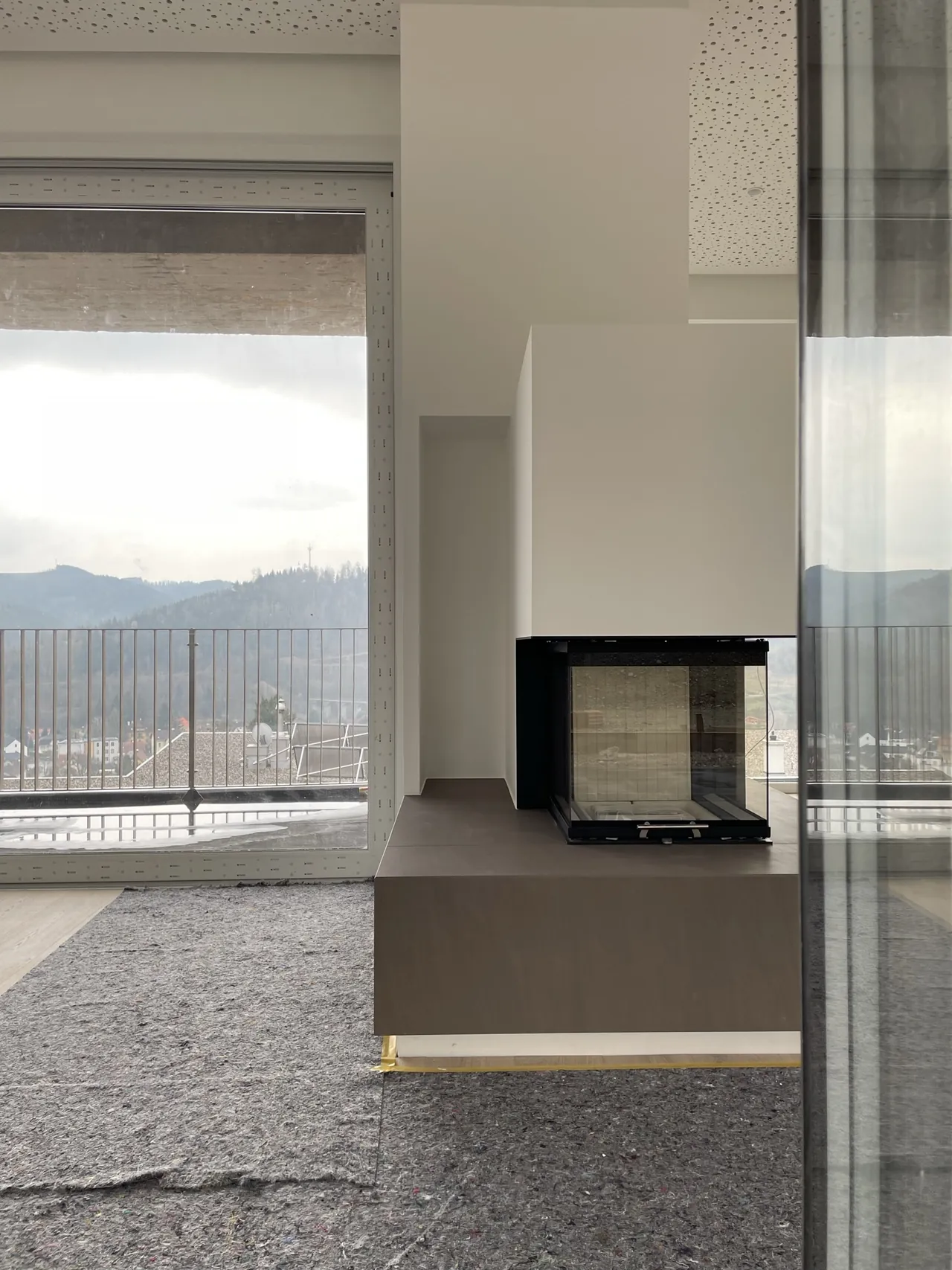Haus H: Wohnraum mit Kamin und Panoramablick über die Landschaft