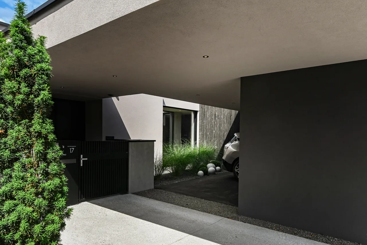 Überdachter Eingangsbereich von Haus L mit Carport und Vorgarten