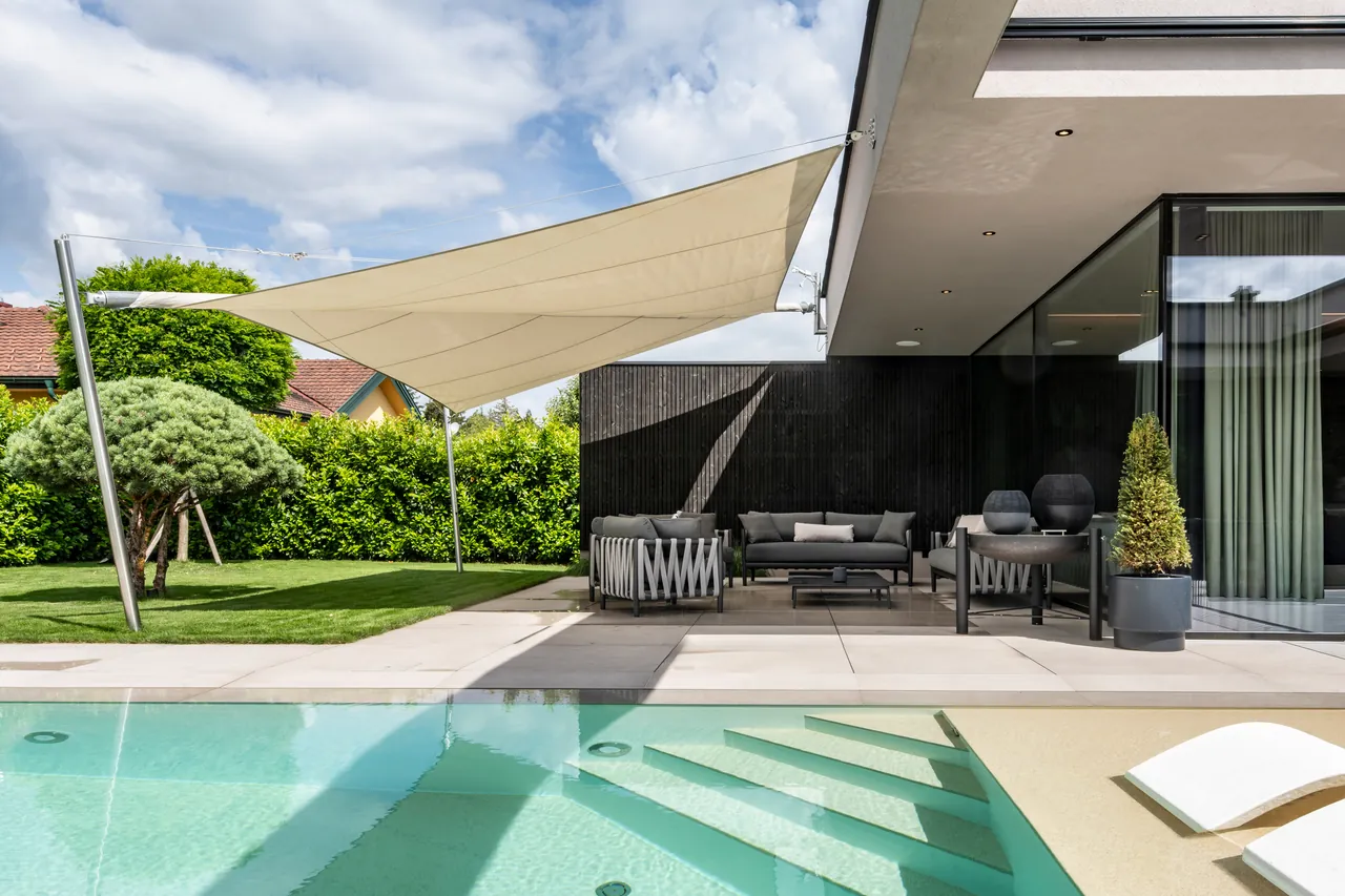 Überdachte Terrasse mit Sitzlandschaft und Blick zum Pool
