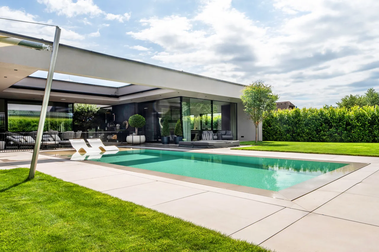 Gartenseite von Haus L mit Pool und Rasenfläche am Tag