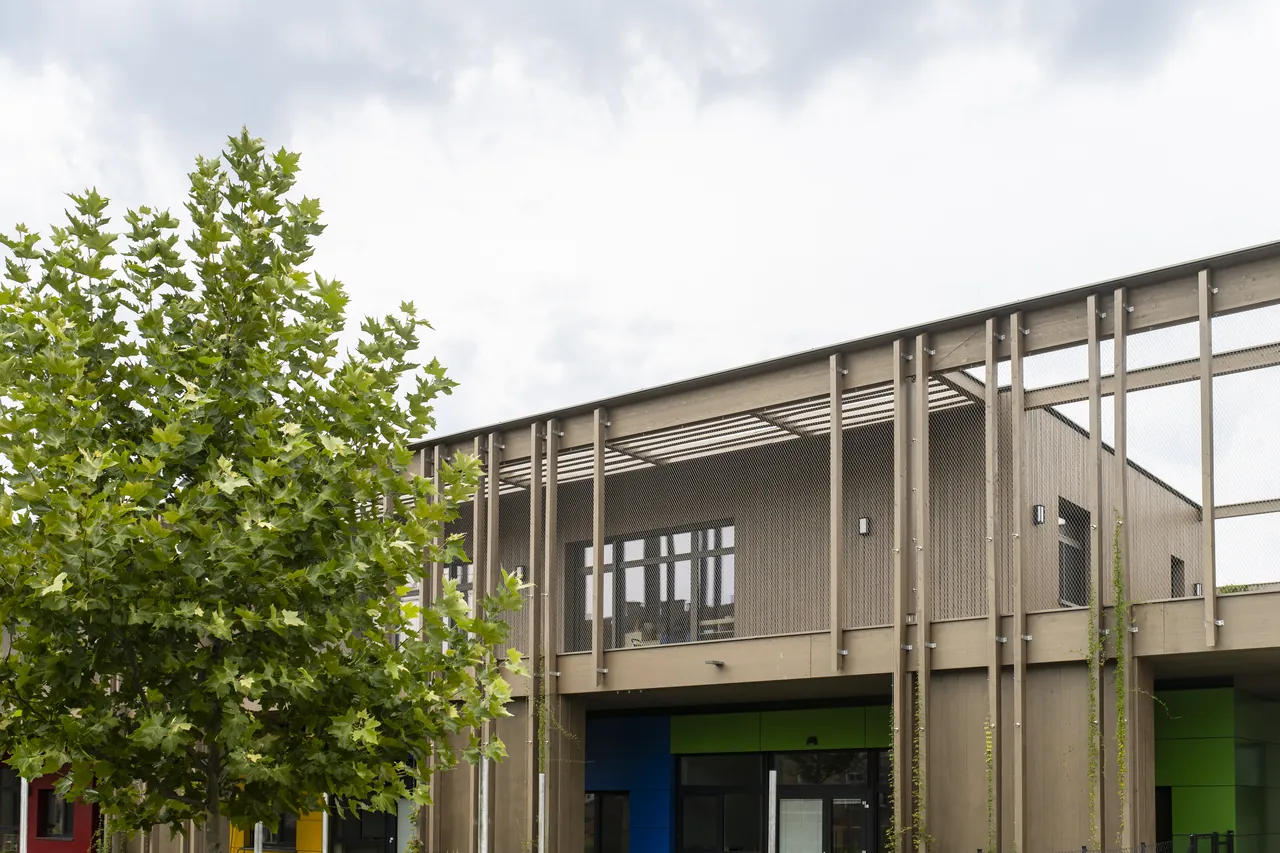 Straßenansicht des Kindergartens mit Baum im Vordergrund