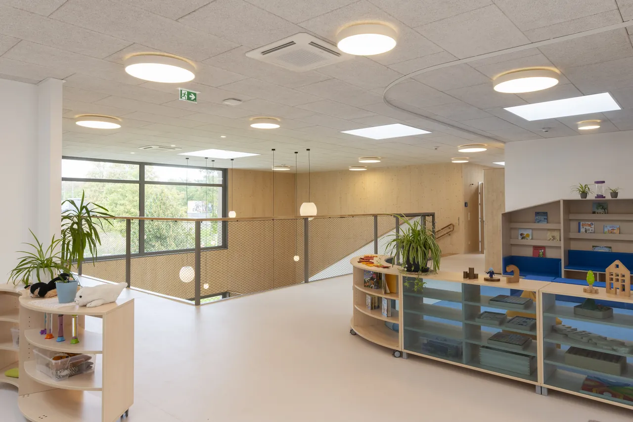 Empfangsbereich mit Sitzbank, Regalen und Spielecke