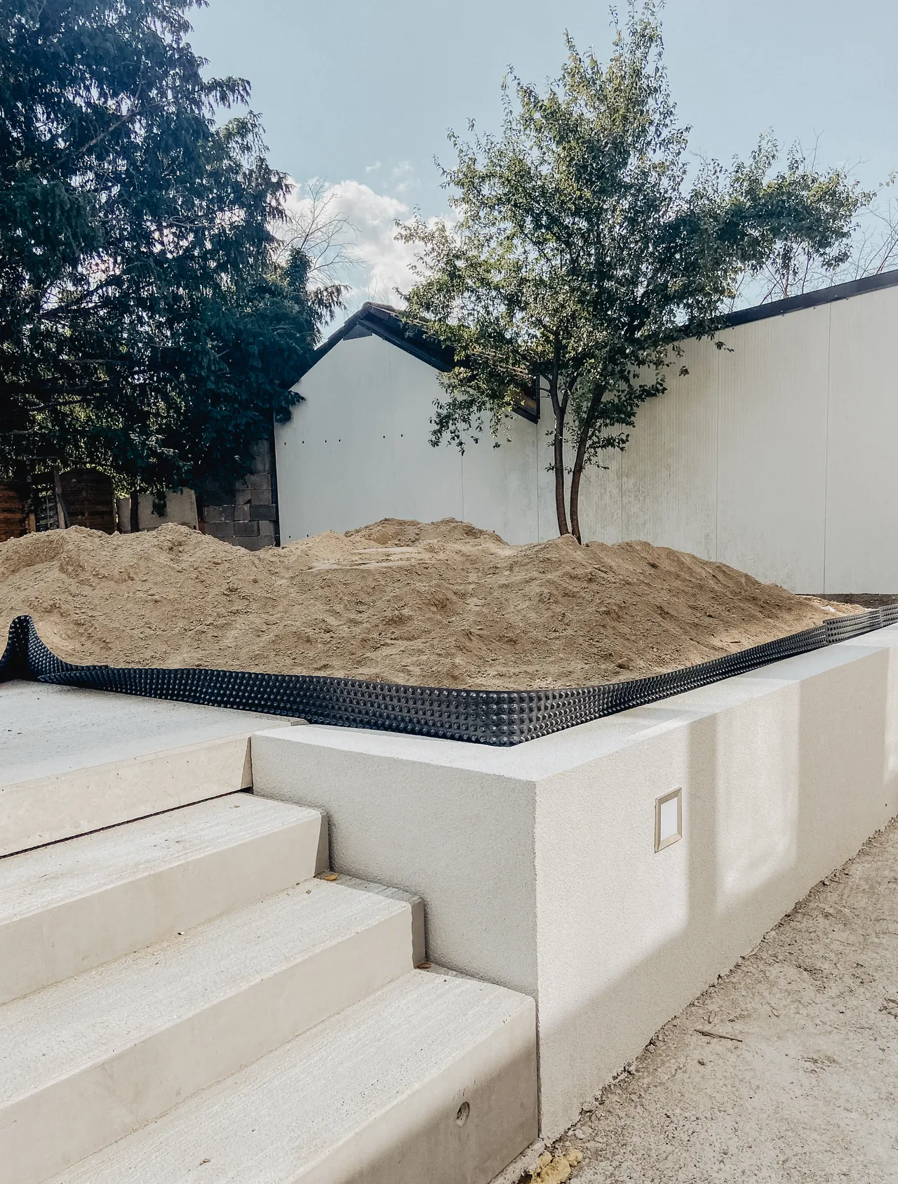 Neu gestalteter Garten mit Stützmauer und Betonstufen